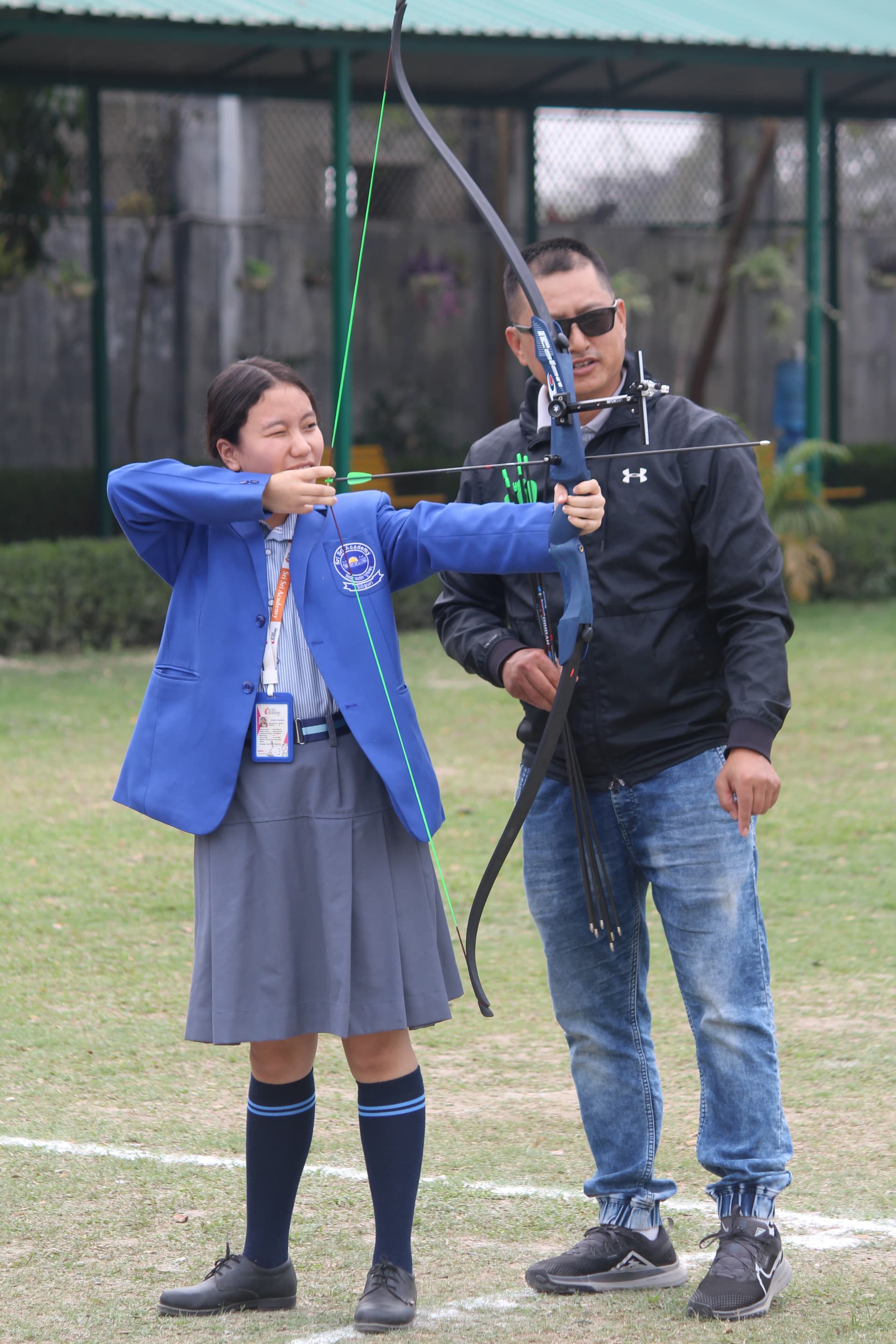 A Sri Sri Academy student practising archery with her coach