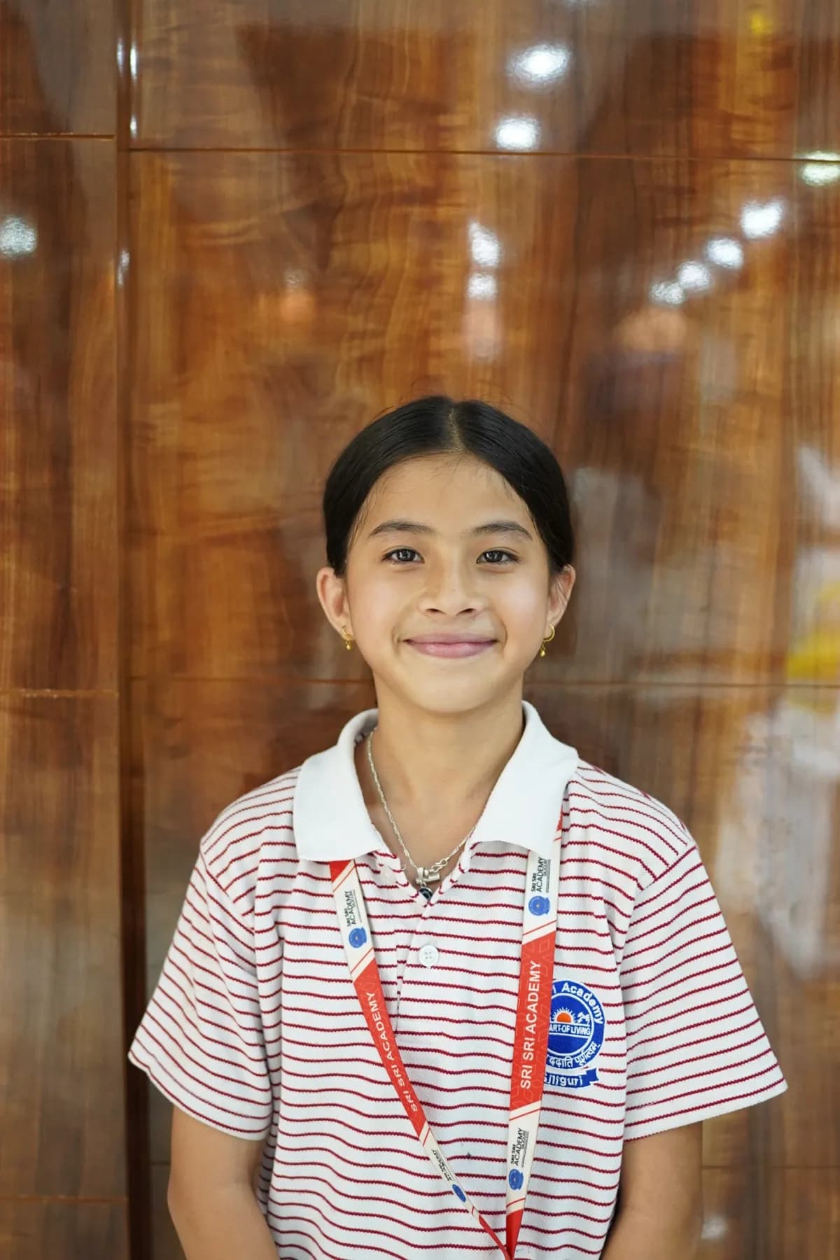 A Sri Sri Academy Siliguri student in school uniform and lanyard