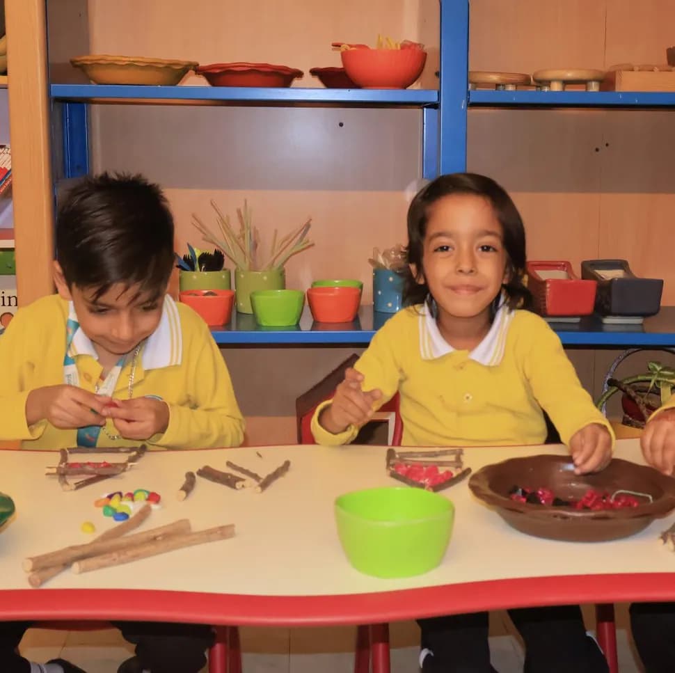 Two children working with natural loose parts at the Montessori table
