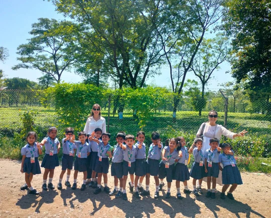 A class walking through a tea garden with their teachers