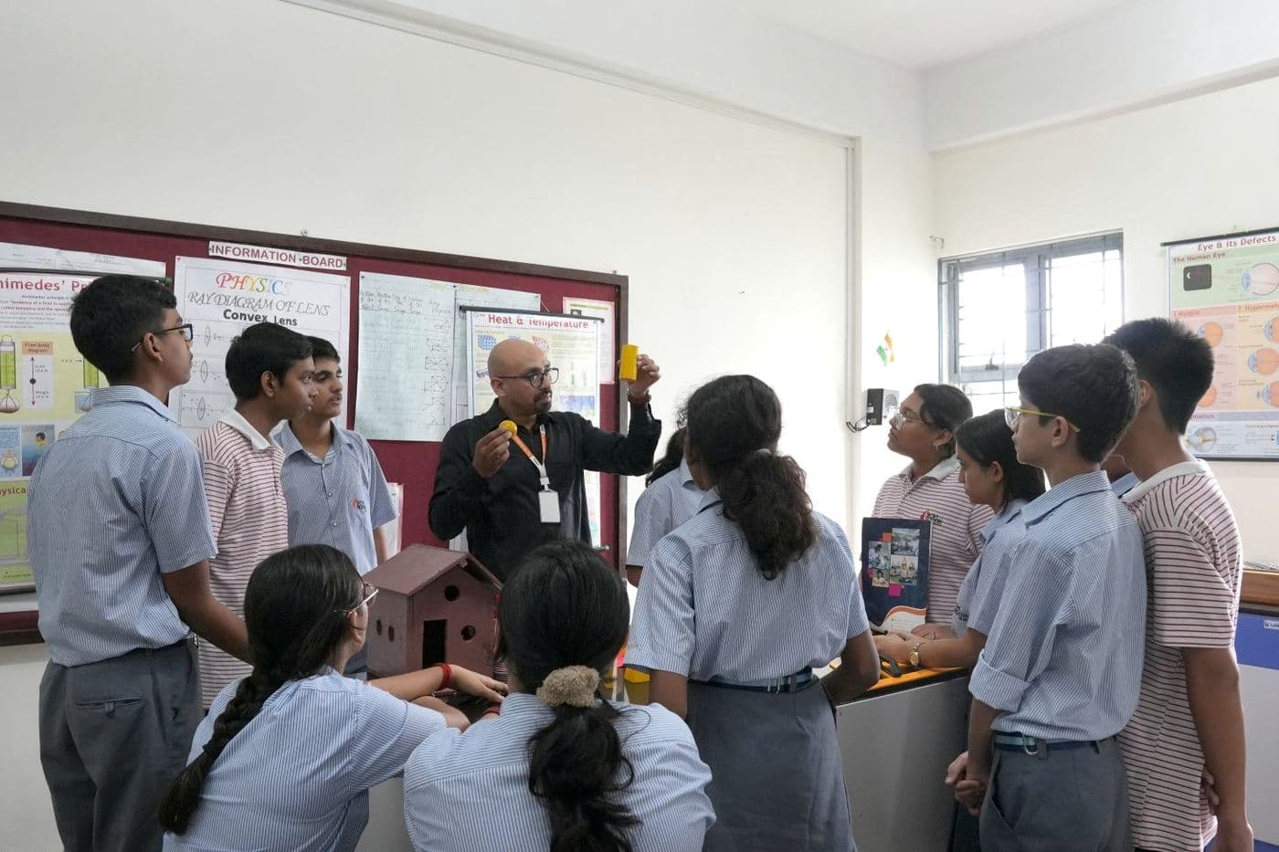 Sri Sri Academy students learning with a teacher in a science laboratory