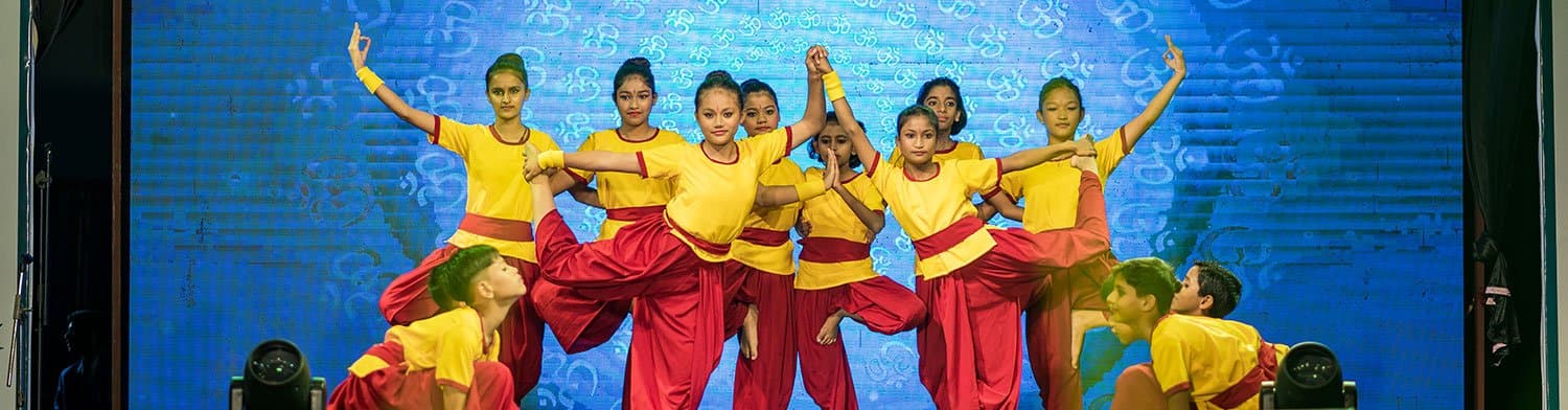 Students performing a group dance on the school stage